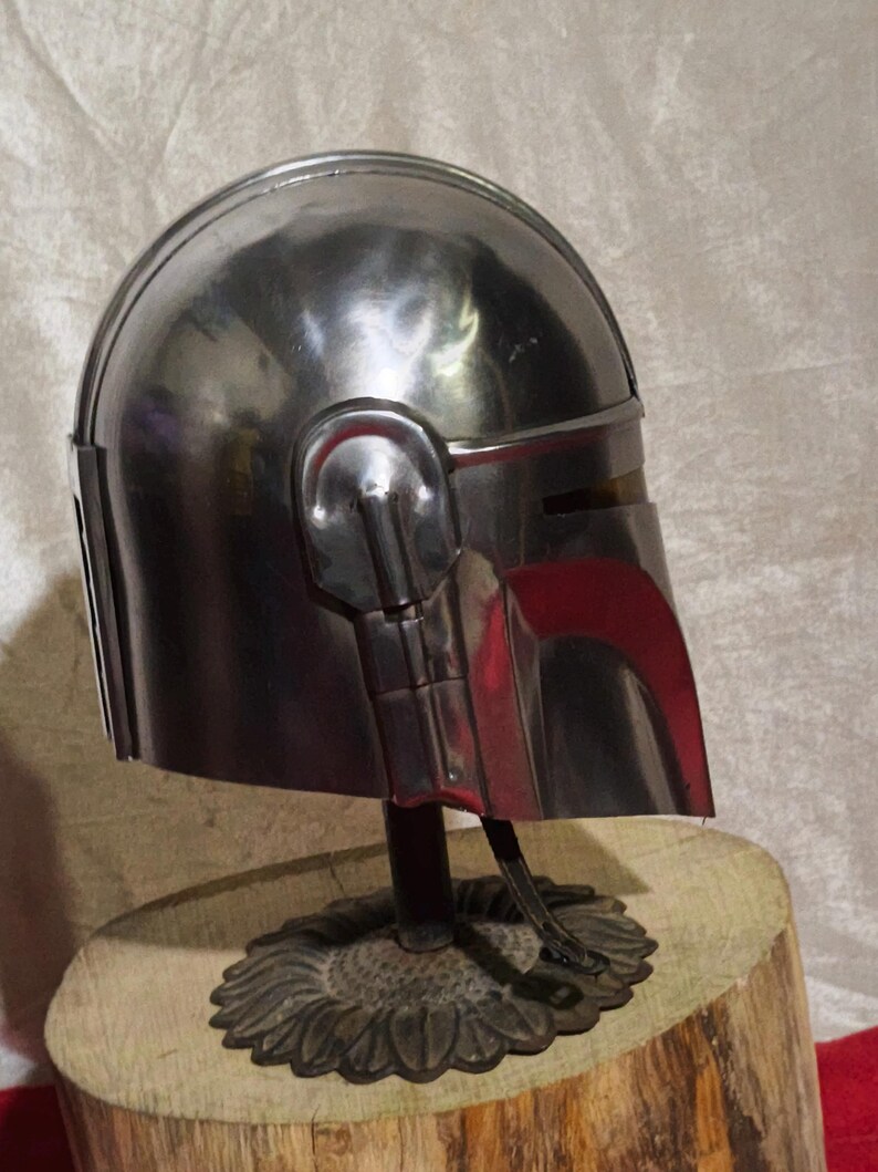 Może przedstawiać: Biały ceramiczny kubek z czarnym uchwytem i napisem "But First, Coffee" pogrubioną, czarną czcionką. Kubek jest ustawiony na rozmytym tle, sugerującym przytulne otoczenie.