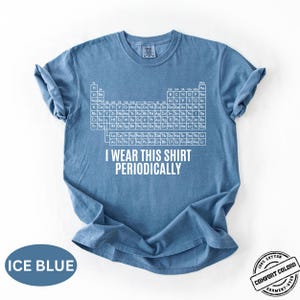 Może przedstawiać: Błękitna koszulka z białym układem okresowym i napisem "I Wear This Shirt Periodically". Koszulka wykonana w 100% z bawełny i barwiona w odzieży.