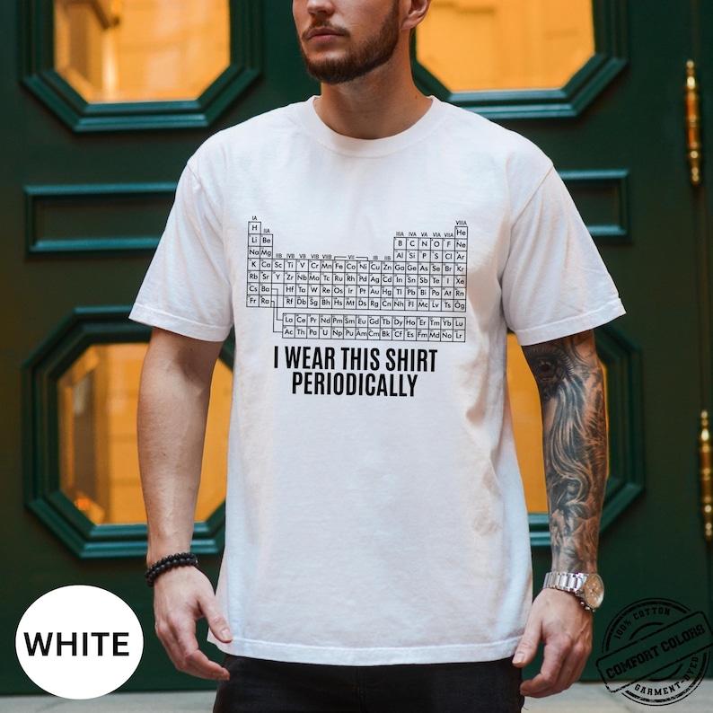 Może przedstawiać: Biała koszulka z czarnym wzorem układu okresowego i napisem "I wear this shirt periodically." Koszulka wykonana jest z miękkiego, wygodnego materiału.