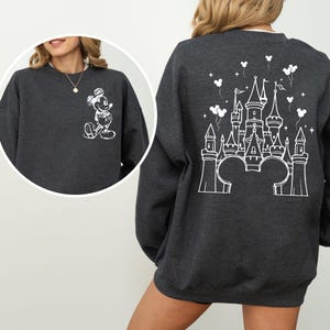 Puede incluir: Sudadera gris oscuro con un dise&ntilde;o de Mickey Mouse blanco en la parte delantera y un castillo en la parte trasera. El dise&ntilde;o incluye globos y estrellas. Un estilo casual y c&oacute;modo.