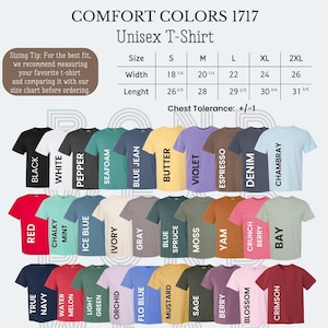 May include: A selection of Comfort Colors 1717 unisex t-shirts in a variety of colours, such as black, white, and red. The image includes a size chart with measurements in inches and a sizing tip. The t-shirts are arranged in rows, showcasing a wide range of hues.