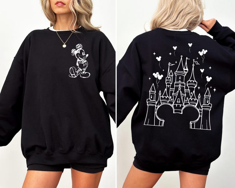 Puede incluir: Sudadera negra con un dise&ntilde;o de Mickey Mouse blanco en la parte delantera y un castillo en la parte trasera. La sudadera tiene cuello blanco y mangas largas. El dise&ntilde;o presenta una silueta de castillo con orejas de Mickey.