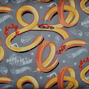 Hot Wheels Autos für Riley Blake Autos und Hot Wheels Autospuren und Logos auf grauem Hintergrund