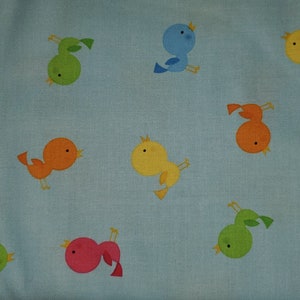Pájaros multicolores sobre fondo azul claro de telas Timeless Treasures