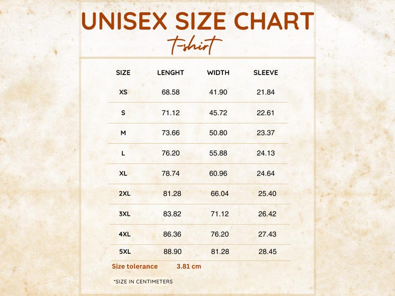 May include: A white unisex t-shirt size chart with brown text. The table lists sizes from XS to 5XL with corresponding length, width, and sleeve measurements in centimeters. The chart includes a size tolerance of 3.81 cm at the bottom.