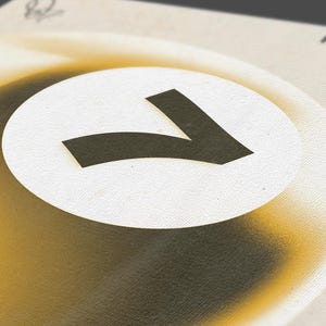 May include: Close-up of a design featuring a large, stylized black number seven inside a white circle. The circle is set against a gradient background of yellow and brown tones. The word "Rio" is visible in the background.