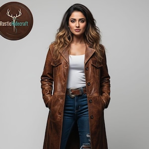 May include: A brown leather coat with a button-down front, pockets, and a belt. The coat is worn over a white top and blue jeans. The coat has a distressed look. The logo "Rustic Hidecraft" is in a circle in the upper left corner.