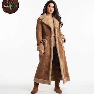 May include: A long, brown shearling coat with a light brown shearling lining and trim. The coat features a notched collar, pockets, and a button closure. The coat is worn with brown boots. The logo for Rustic Hidecraft is in the upper left corner.