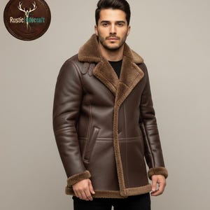 Peut inclure: Un manteau en cuir marron avec un col et une doublure en peau de mouton. Le manteau a une fermeture à boutons, des poches latérales et une bordure en peau de mouton sur les poignets. Un signe en bois avec le texte "Rustic Hidecraft" est dans le coin supérieur gauche.