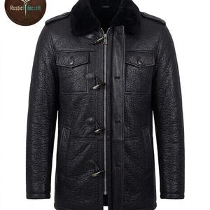 Puede incluir: Una chaqueta de cuero negro texturizado con cuello de piel sintética negra, cremallera central plateada y tres cierres de palanca. La chaqueta incluye dos bolsillos en el pecho con solapas abotonadas y charreteras en los hombros.