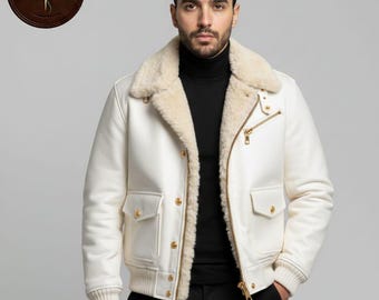 May include: A white leather jacket with a cream-colored shearling collar and lining. The jacket features a zip closure, two front pockets, and gold-colored hardware. The jacket is part of a clothing collection.