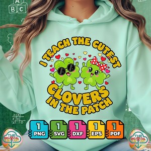 May include: A pale green hoodie with the slogan "I TEACH THE CUTEST CLOVERS IN THE PATCH". The design shows two cartoon clovers, one with sunglasses and one with a bow. File type icons for PNG, SVG, DXF, EPS, and PDF are below.