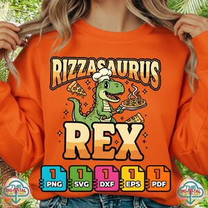 Puede incluir: Sudadera naranja con un gráfico de un dinosaurio verde chef sosteniendo pizza y el texto "Rizzasaurus Rex". El diseño incluye rebanadas de pizza y estrellas. Debajo del diseño hay iconos de tipo de archivo: PNG, SVG, DXF, EPS y PDF.