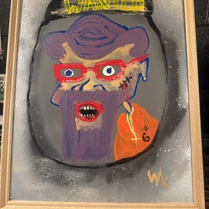 Puede incluir: Pintura enmarcada que presenta un retrato estilizado de una persona con cabello morado, gafas rojas y barba morada. La palabra "WANTED" está escrita en amarillo. La obra de arte tiene una prenda naranja y un fondo gris.