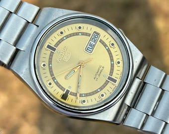 Reloj Seiko 5 automático vintage para hombre, esfera dorada, día y fecha, 17 joyas, Japón, acero inoxidable, estilo retro.