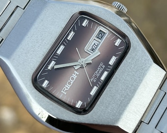 Reloj automático vintage Ricoh / Esfera granate con efecto sol, día y fecha
