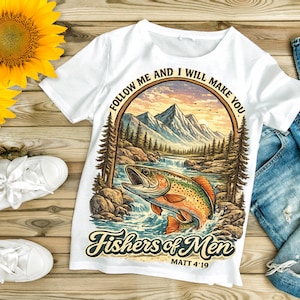 Peut inclure: T-shirt blanc avec un motif coloré d'un poisson sautant hors de l'eau, des montagnes et des arbres. Le texte "Follow Me and I Will Make You Fishers of Men" est imprimé. Le t-shirt est associé à un jean bleu et des chaussures blanches.