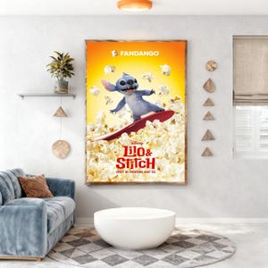 May include: A framed movie poster for Disney's "Lilo & Stitch" featuring the character Stitch surfing on a red surfboard through popcorn. The poster has a yellow and orange background with the Fandango logo at the top. The movie title is at the bottom.