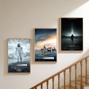 Puede incluir: Tres pósteres rectangulares de pared con la película Interstellar. El póster de la izquierda muestra a un astronauta en un paisaje nevado. El central muestra a un astronauta en el agua con una nave espacial. El de la derecha muestra una silueta ante un haz de luz.