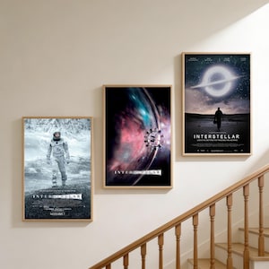 Può includere: Tre poster cinematografici rettangolari incorniciati di Interstellar su una parete. Il poster a sinistra mostra un astronauta in un paesaggio innevato. Il poster centrale raffigura un'astronave vicino a una nebulosa. Quello a destra mostra una silhouette davanti a un buco nero.