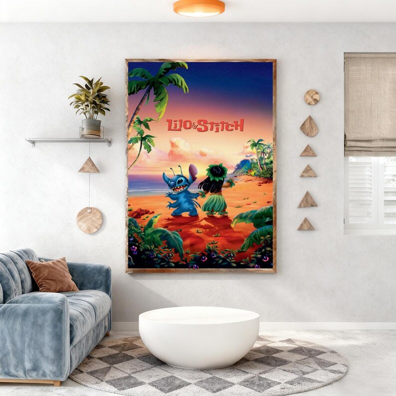 May include: A framed print of the animated film "Lilo & Stitch" featuring Stitch and Lilo on a beach. The artwork has a vibrant colour palette with a sunset backdrop, palm trees, and lush greenery. The title "Lilo & Stitch" is displayed in red.