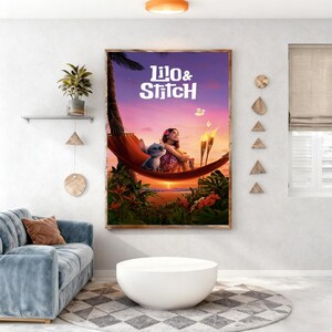 May include: A framed poster featuring the animated characters Lilo and Stitch. The artwork depicts Lilo and Stitch in a hammock with a sunset background. The poster has a wooden frame and is displayed on a white wall.