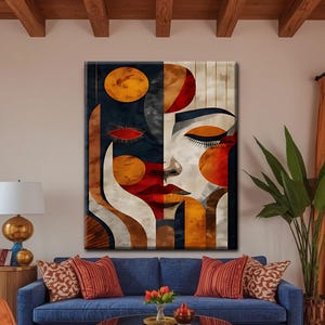 May include: A rectangular wall art canvas featuring a split-face portrait design. The left side displays dark navy and deep red tones, while the right side features cream and gold hues. Abstract geometric shapes and circular elements define the facial features.