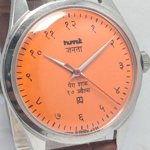 May include: A white ceramic mug with a black handle and the text "But First, Coffee" in a black, bold font. The mug is on a white surface.