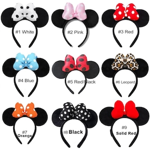 Könnte beinhalten: Eine Sammlung von neun schwarzen Haarreifen mit runden Ohren und verschiedenen Schleifen, beschriftet mit #1 White, #2 Pink, #3 Red, #4 Blue, #5 Red/Black, #6 Leopard, #7 Orange, #8 Black und #9 Solid Red, mit Punkten, Leopardenmuster und unifarben.