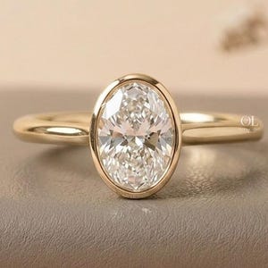 Oval lab grown diamond bezel engagement ring in gold
