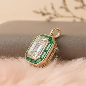 Luxury emerald cut diamond pendant surrounded by rectangular green gemstones in a geometric gold frame.
