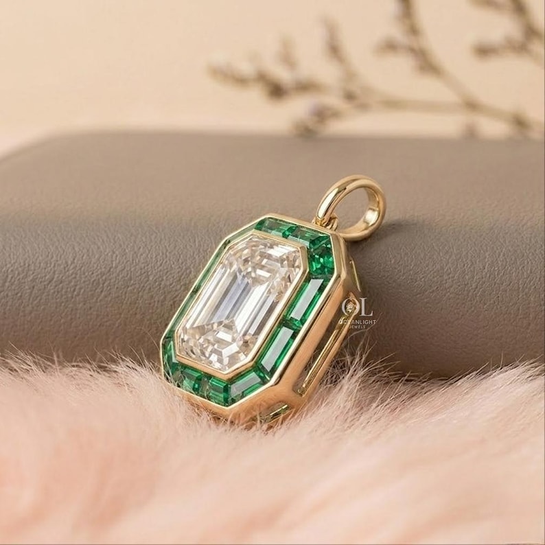 Luxury emerald cut diamond pendant surrounded by rectangular green gemstones in a geometric gold frame.