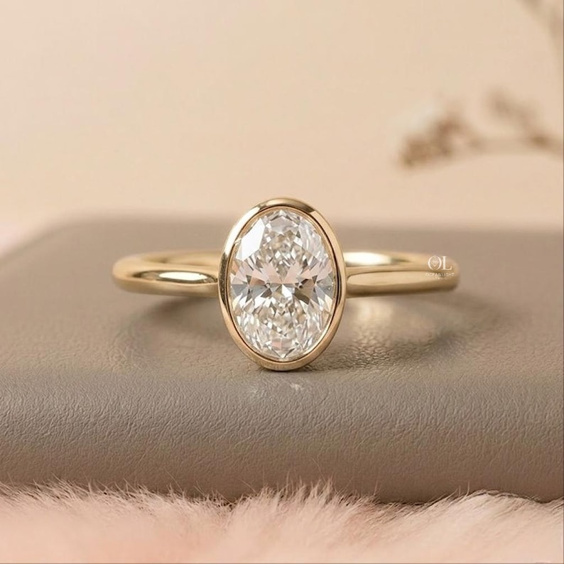 Oval lab grown diamond bezel engagement ring in gold