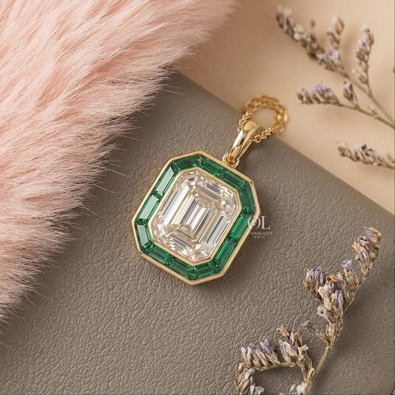 Step cut lab grown diamond pendant with vibrant green emerald halo and polished yellow gold bail.