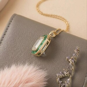 Green emerald halo pendant with a rectangular step cut center diamond for women's fine jewelry.