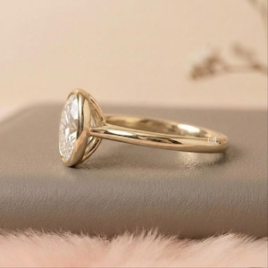 Gold oval bezel ring with lab grown diamond center