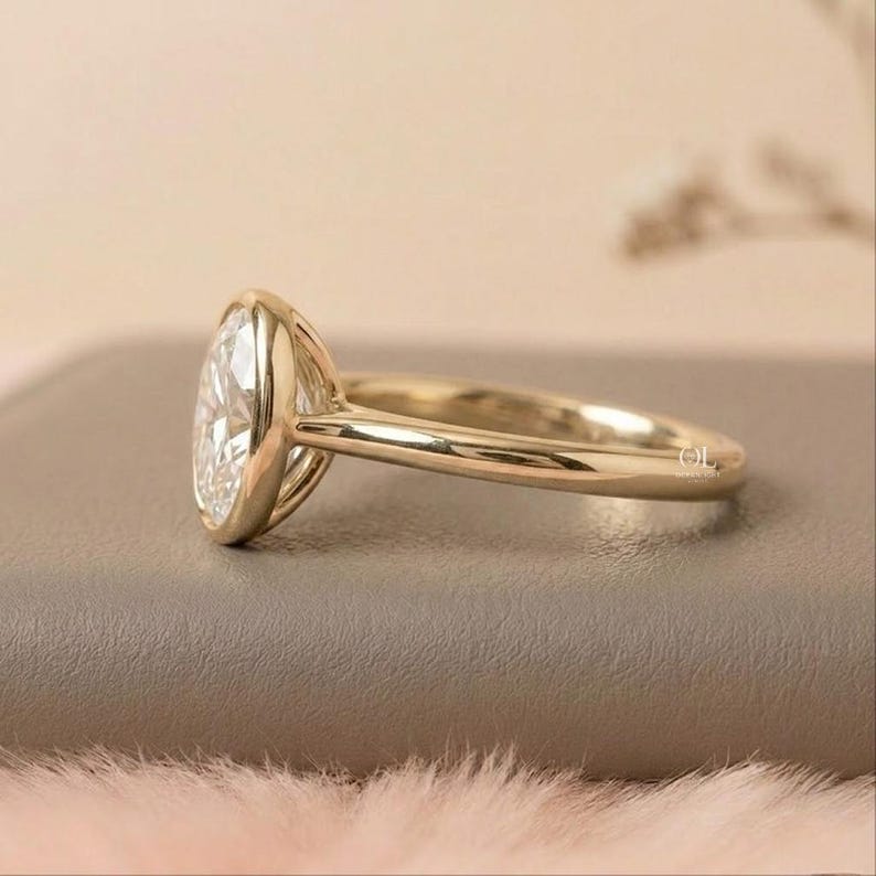 Gold oval bezel ring with lab grown diamond center