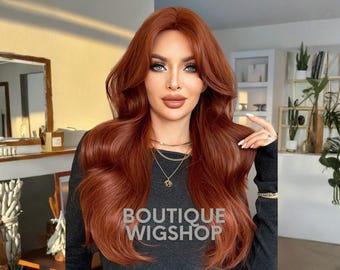 May include: A long, wavy auburn wig with a lace front. The wig is styled with a side part and layers. The text "BOUTIQUE WIGSHOP" is printed on the dark gray shirt. The wig is designed to look natural and is suitable for various occasions.