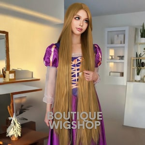 Könnte beinhalten: Eine lange, goldblonde Perücke mit Mittelscheitel, getragen von einer Person in einem lila-weißen Kleid. Das Kleid hat ein Mieder im Korsettstil. Der Text "BOUTIQUE WIGSHOP" ist auf dem Kleid zu sehen. Die Perücke scheint für ein Kostüm gestylt zu sein.