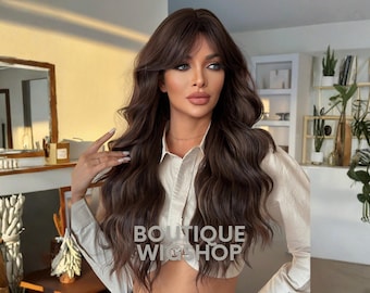 May include: A long, wavy brown wig with bangs. The wig has a natural look and is styled with loose curls. The text "BOUTIQUE WIG SHOP" is visible on the front of the shirt.