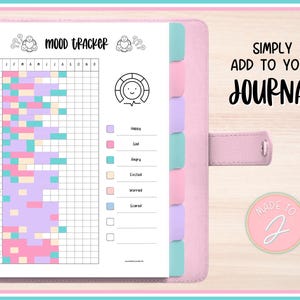 May include: A pink planner with a mood tracker chart and color-coded sections for emotions. The chart is filled with pastel colors. Text on the page reads "MOOD TRACKER" and "SIMPLY ADD TO YOUR JOURNAL". A round sticker says "MADE TO J".