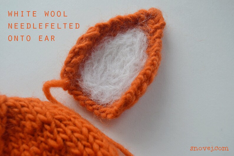 May include: Close-up of a knitted orange ear with white wool needle felted onto the inside. The text "WHITE WOOL NEEDLE FELTED ONTO EAR" is visible above the ear.