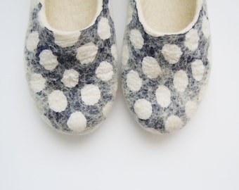May include: A pair of white felt slippers with a navy blue polka dot pattern.