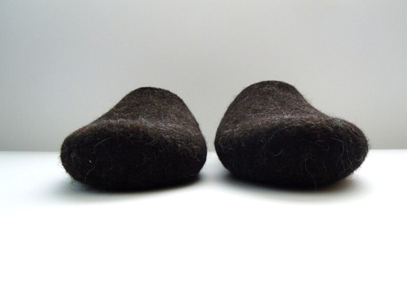 Peut inclure: Une paire de pantoufles en laine marron fonc&eacute;. Les pantoufles sont faites d'un mat&eacute;riau &eacute;pais et duveteux et ont une pointe arrondie.