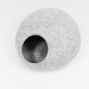 May include: A gray felt cat bed shaped like a sphere with a large opening for entry.