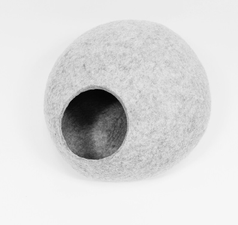 May include: A gray felt cat bed shaped like a sphere with a large opening for entry.