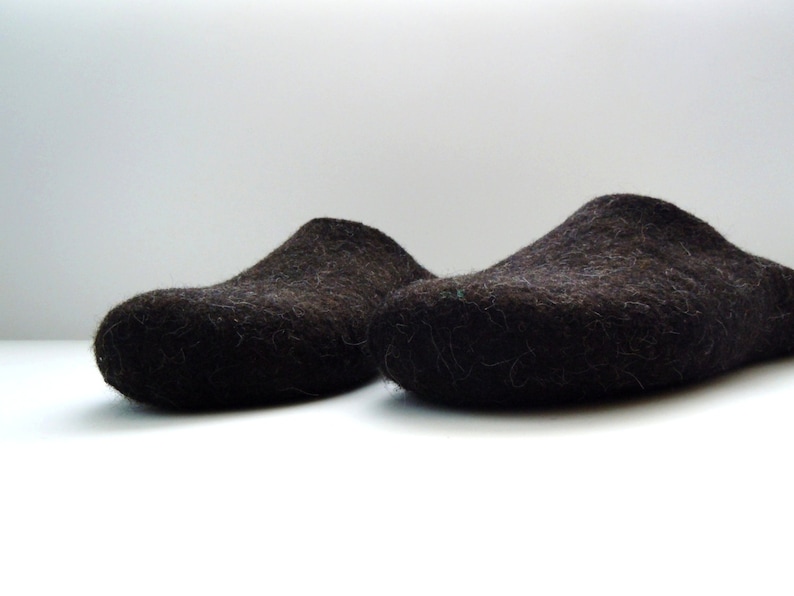 Peut inclure: Deux paires de pantoufles en laine marron fonc&eacute;. Les pantoufles sont faites d'un mat&eacute;riau &eacute;pais et duveteux et ont une pointe arrondie.