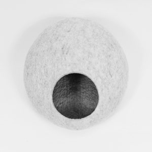 May include: A gray felt cat bed shaped like a sphere with a round opening in the front.