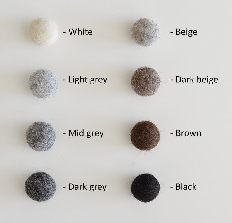 May include: Eight felt balls in different colors: white, beige, light grey, dark beige, mid grey, brown, dark grey, and black. Each ball is labeled with its color.