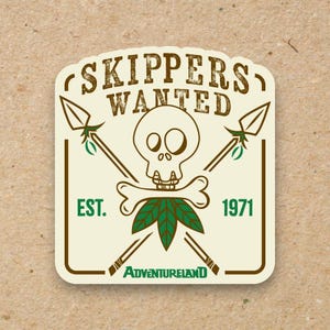 May include: A rectangular sticker with a vintage design. The sticker features a skull and crossbones with crossed spears, a leaf design, and the text "SKIPPERS WANTED" and "ADVENTURELAND". The sticker also includes the year "1971".